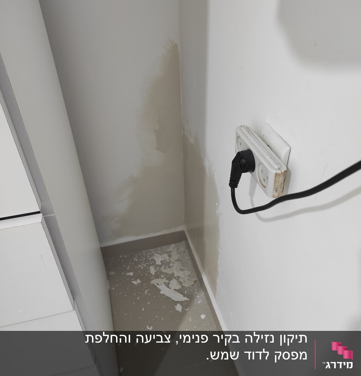 קיר עם טיח מתקלף ושקע חשמלי